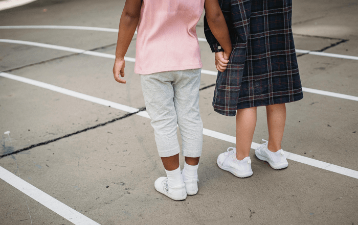 Two school kids holding hands
